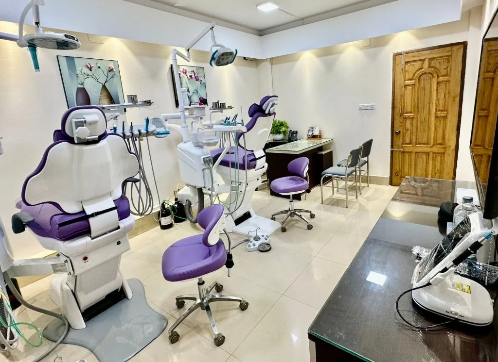 A two-chair operatory at RH Dental Care Banasree with delivery units, overhead lights and a clinician workstation between the chairs.